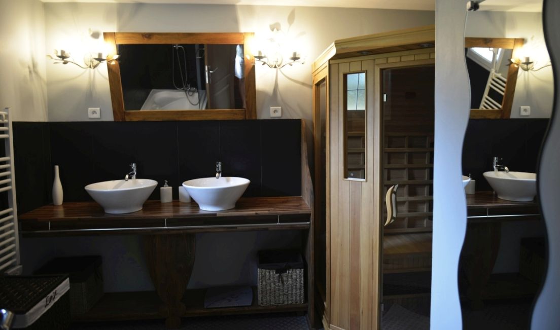 Salle de bain avec deux vasques et sauna au Chalet Clairlune